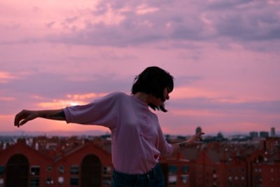 woman with outstretched arms at sunset