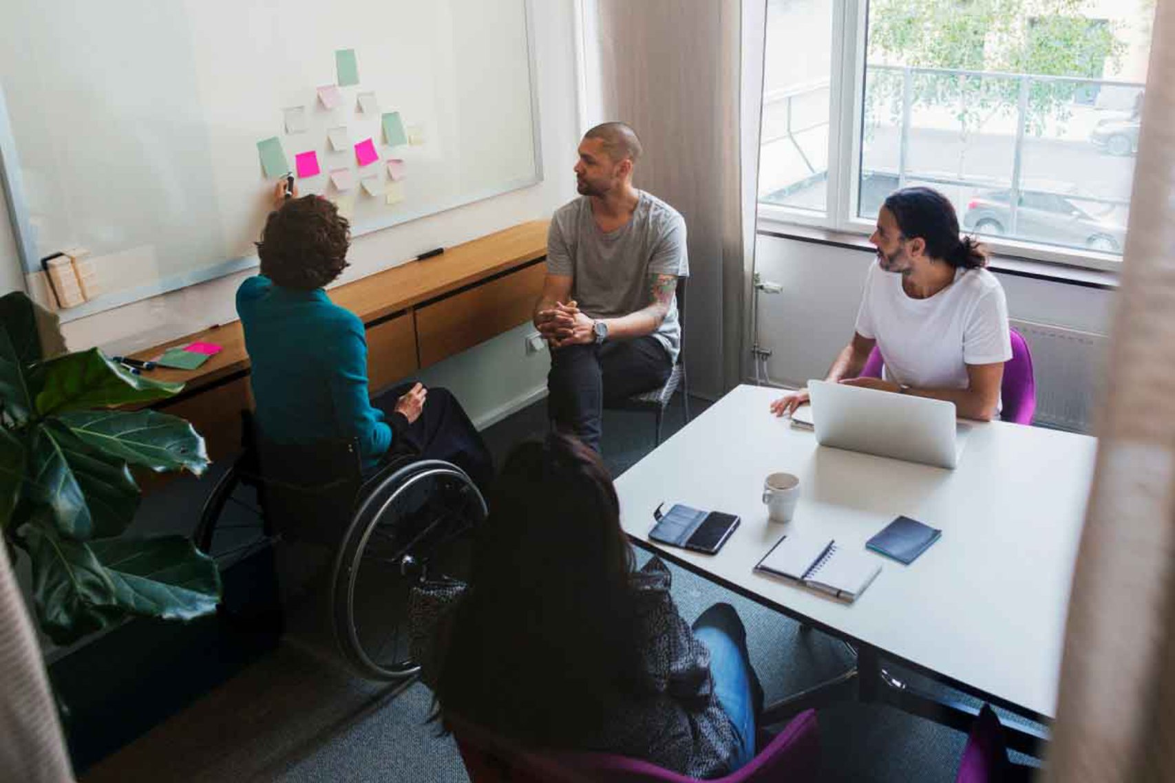 4 People Man on the Wheelchair Pointing to the Stickynotes