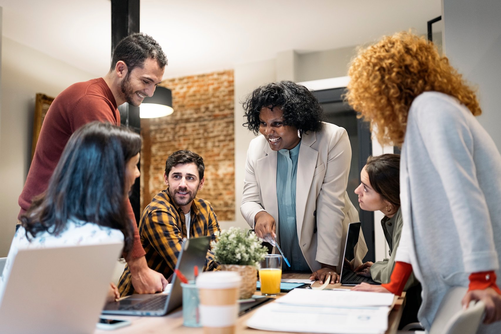 Group discussing details of project while working together in a modern office.