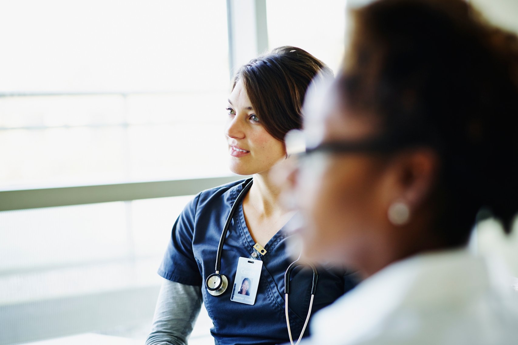 Female nurse listening during medical team meeting