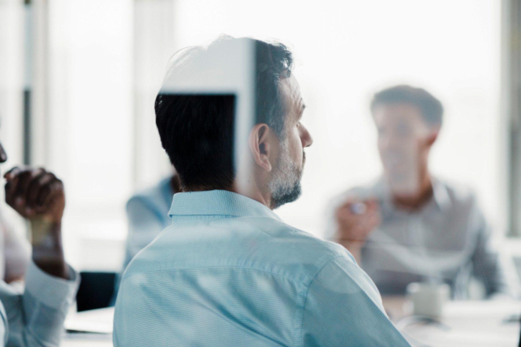 A Guy with Beard Wearing Light Blue Polo in a Meeting with Team