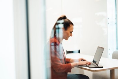 A woman smiling in front of her laptop