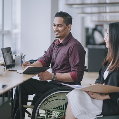 A man in wheelchair and a woman sitting beside him