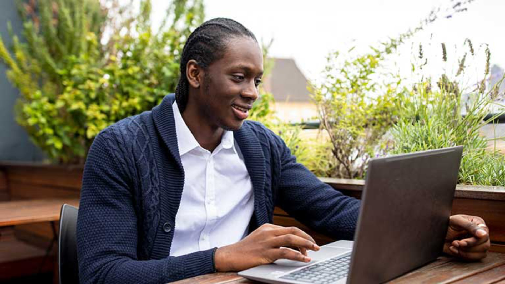 A man with braids using his laptop