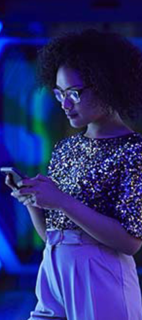 Woman standing in a blue tunnel using her phone