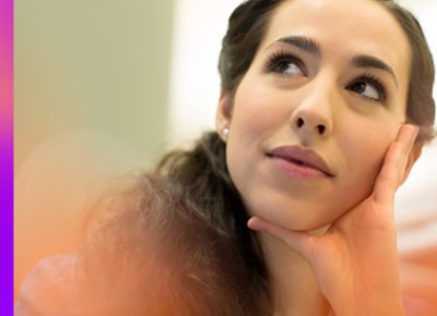 A woman touching her face while looking up