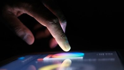 Hand pointing to a touch screen while on