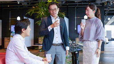 Three collegues chatting while holding white cups