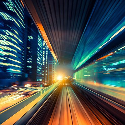 The image is of a blurry road at night in the city with lights and traffic