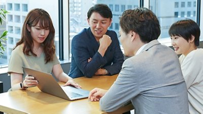 Group of people discussing in front of computer