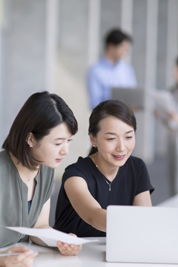 Accenture Japan Unit Marquee people talking and working in a laptop