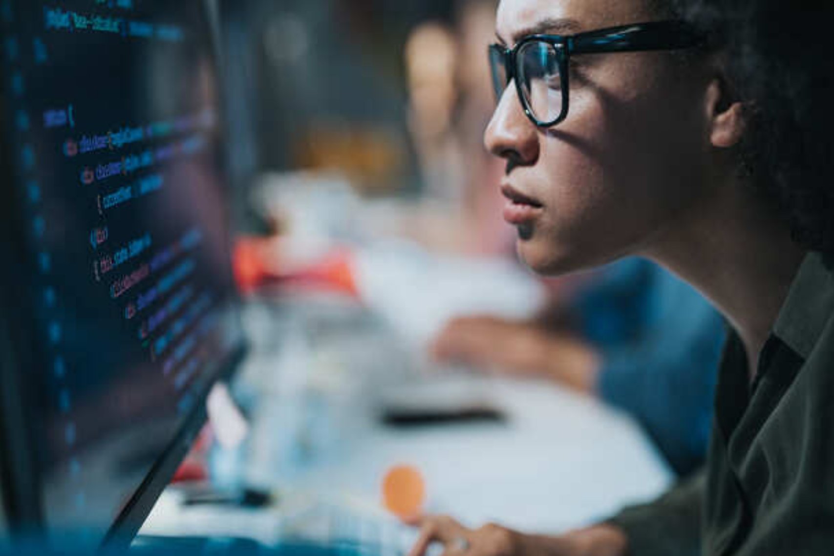 woman with glasses programming in computer.