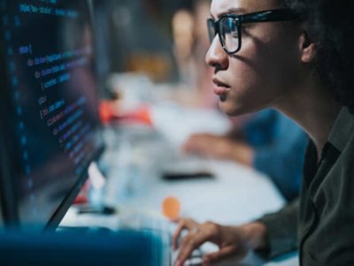 Man with glasses programming in computer.