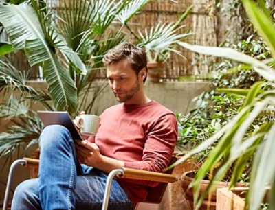 Man using digital tablet while having coffee