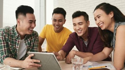 Students gather looking at ipad