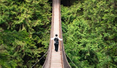 Image of a man walking on a hanging bridge