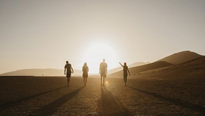 A group of people on the desert enjoying sunset