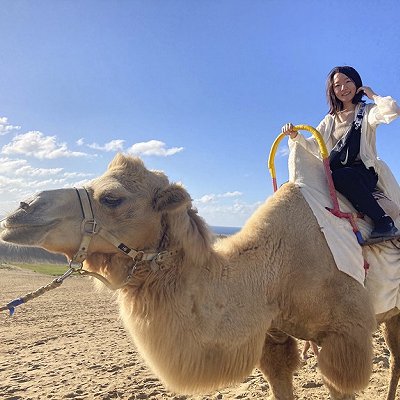 Woman smiling while riding a camel