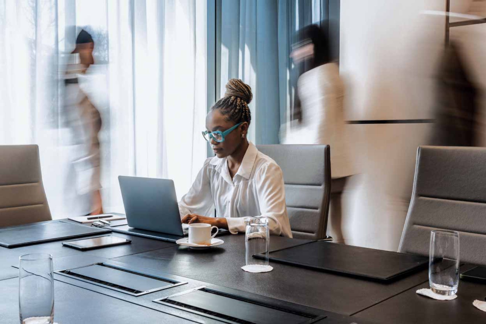 woman typing with busy people in the background