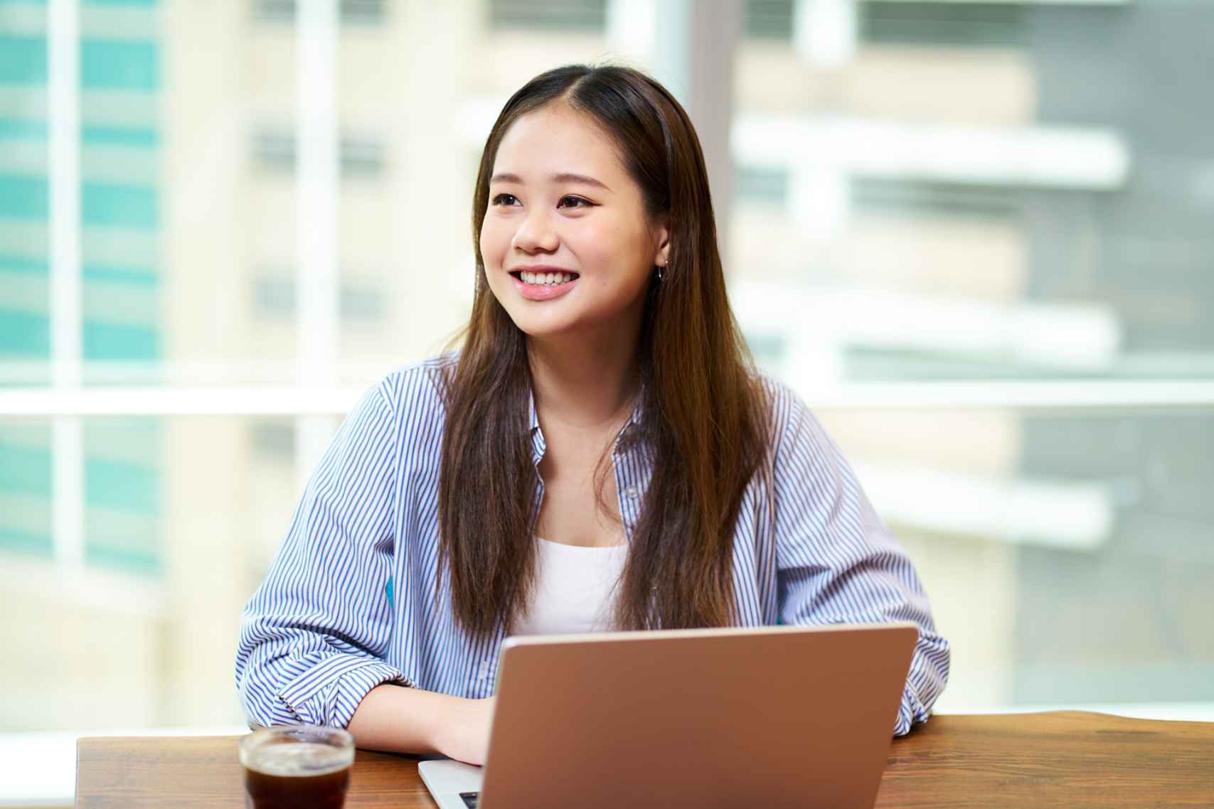 Smiling young woman working on laptop
