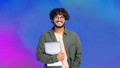 A curly haired guy wearing glasses smiling