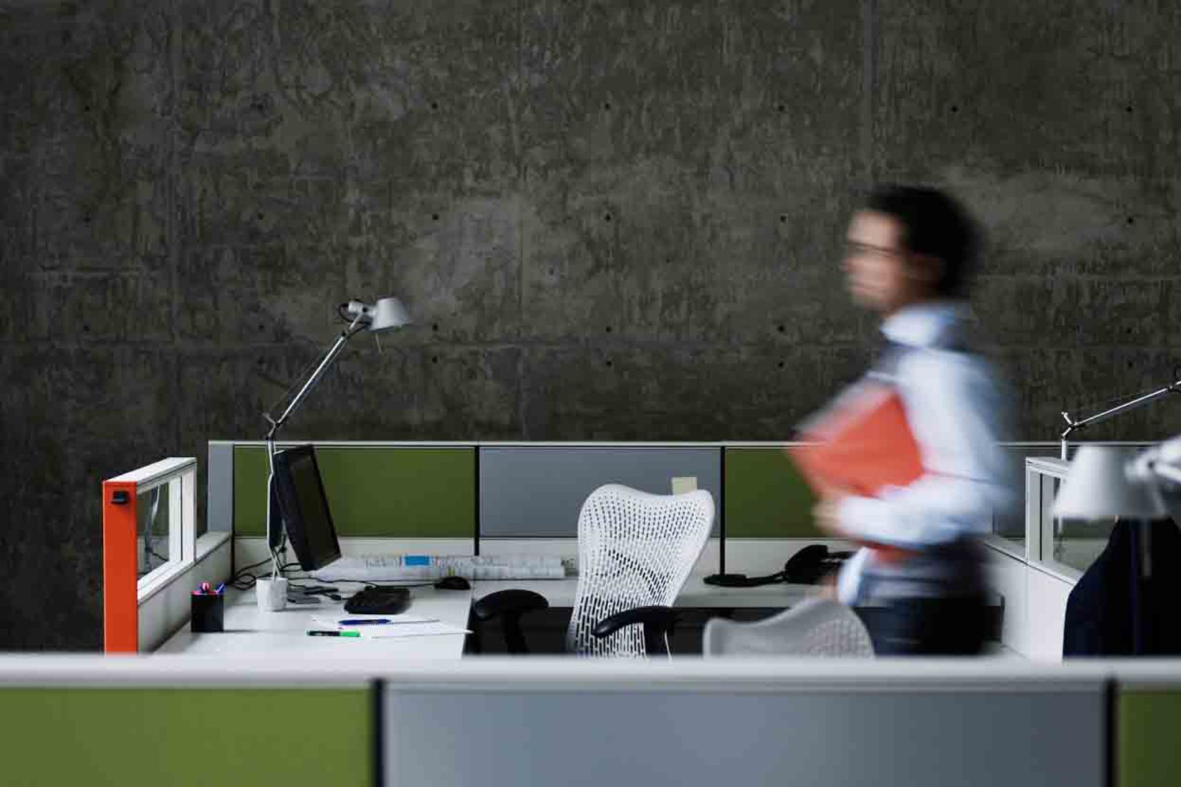 A man walking in motion between cubicles in the office