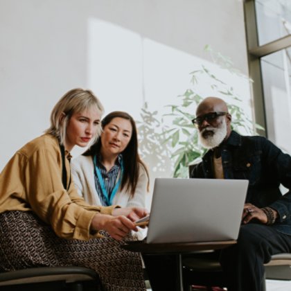 Three people in front of laptop