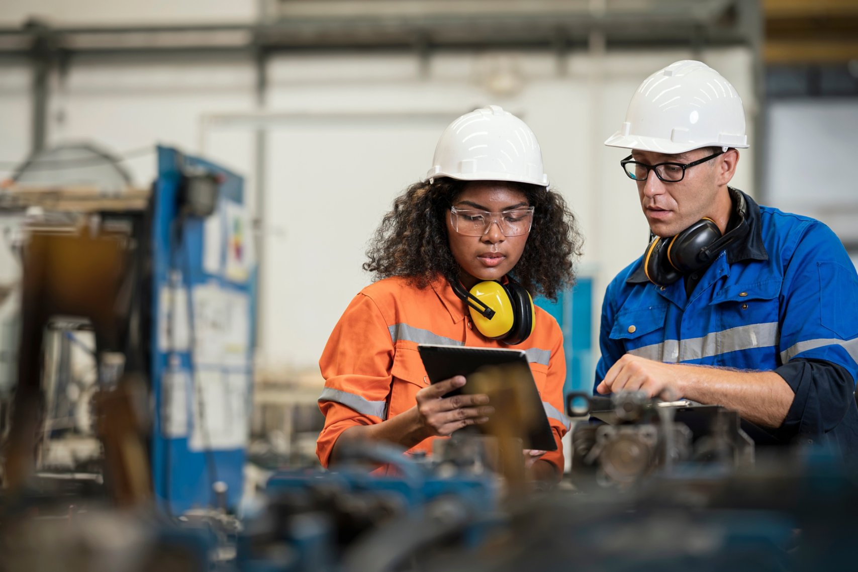 Two machinery workers looking at tablet