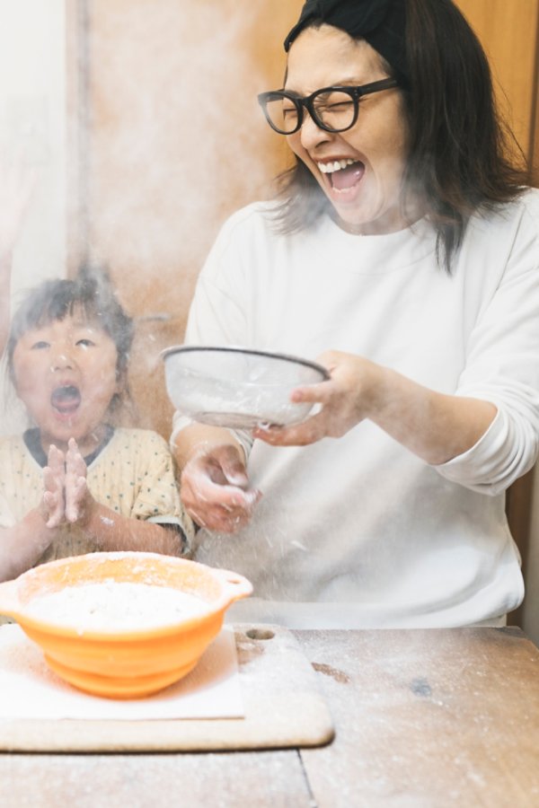 Flour is swirling in the air and Asian family are surprised  while kneading flour.