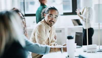 Man with glasses at the office chatting with workmates