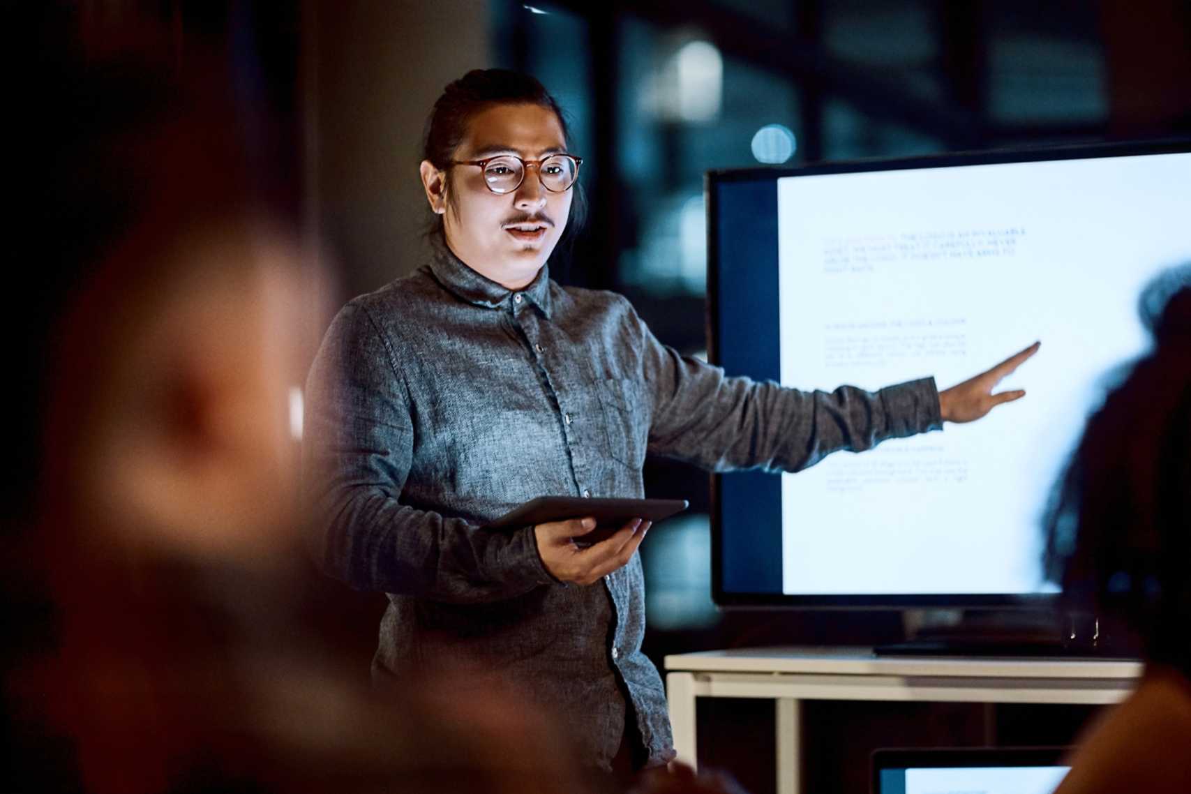 hot of a young businessman delivering a presentation during a late night meeting at work