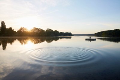 Lake and circular pattern on water surface at sunrise in summer