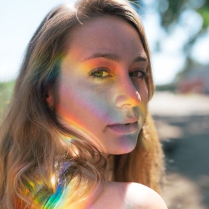 A woman smiling with rainbow on her cheek