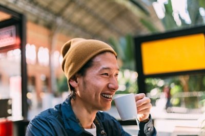 Guy wearing bonnet holding white mug