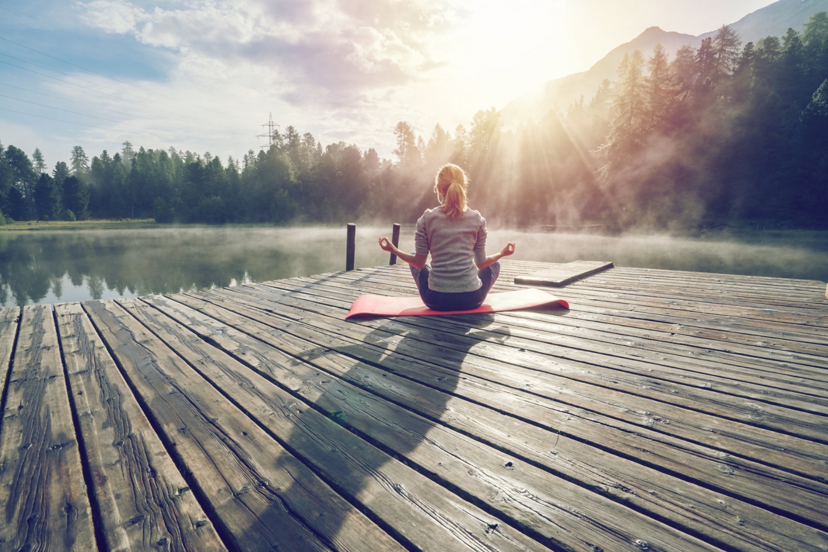 Girl meditating along the lake