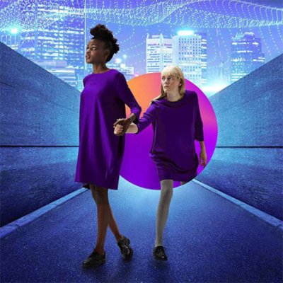 Two women in purple holding hands