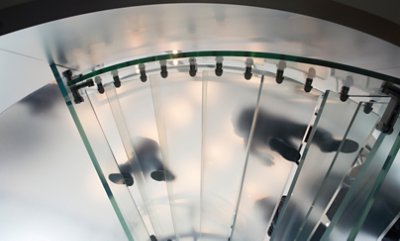 A foot steps against a sky background on a clear staircase