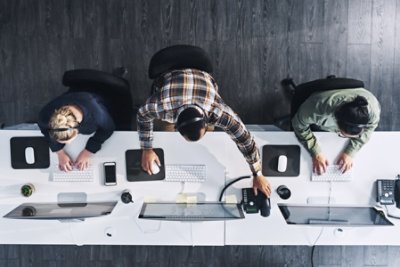 Three people working front computer