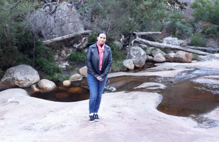 An image of Jemima Khoo, posing in front of a rocky mountain