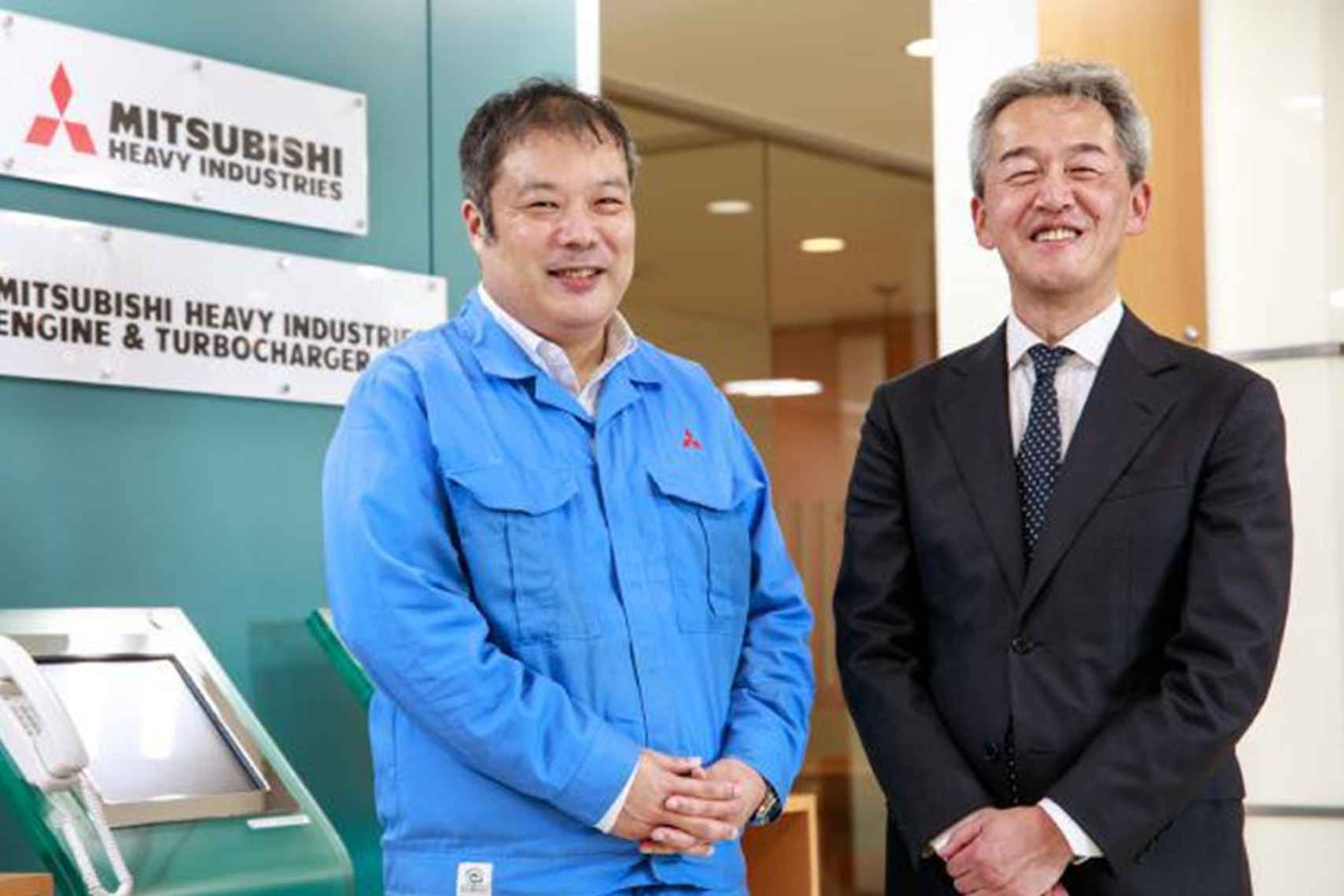 男性2名の写真（左：三菱重工業株式会社 ICTソリューション本部 BPI部 ソフトウェア4グループ 2チーム 上席主任 菅 佳紀 氏右：アクセンチュア株式会社 テクノロジーコンサルティング本部 インテリジェントソフトウェア エンジニアリングサービスグループ アソシエイト・ディレクター 中野 恭秀）