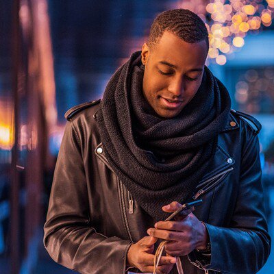 Man With a Cell Phone and Several Gifts in His Hand Featured