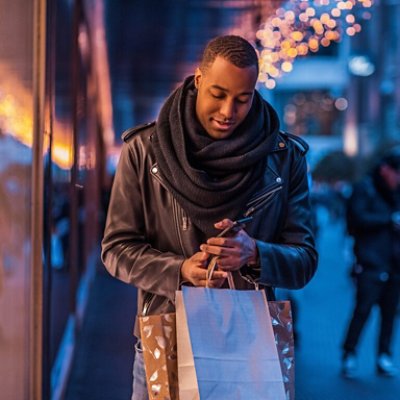 Man With a Cell Phone and Several Gifts in His Hand Hero