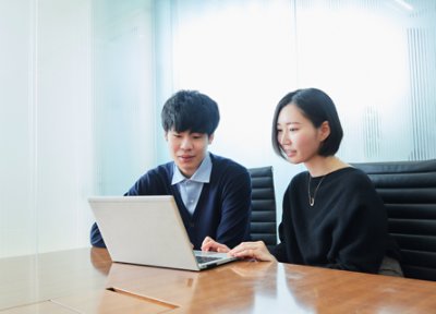 A man and woman looking at a laptop