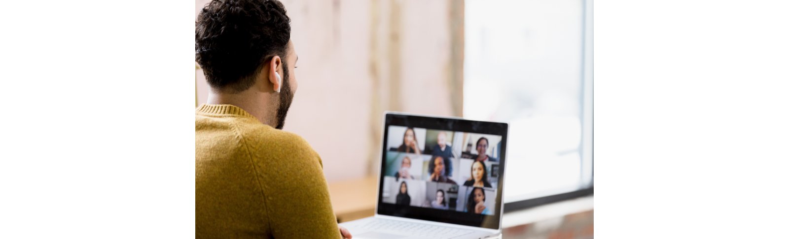 Man wearing mustard color sweatshirt videocall