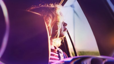 Girl watching the landscape behind a car window