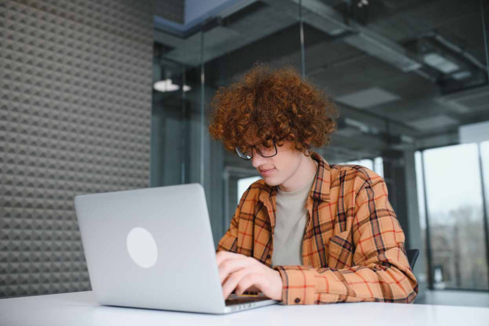 Student wearing brown checkered typing