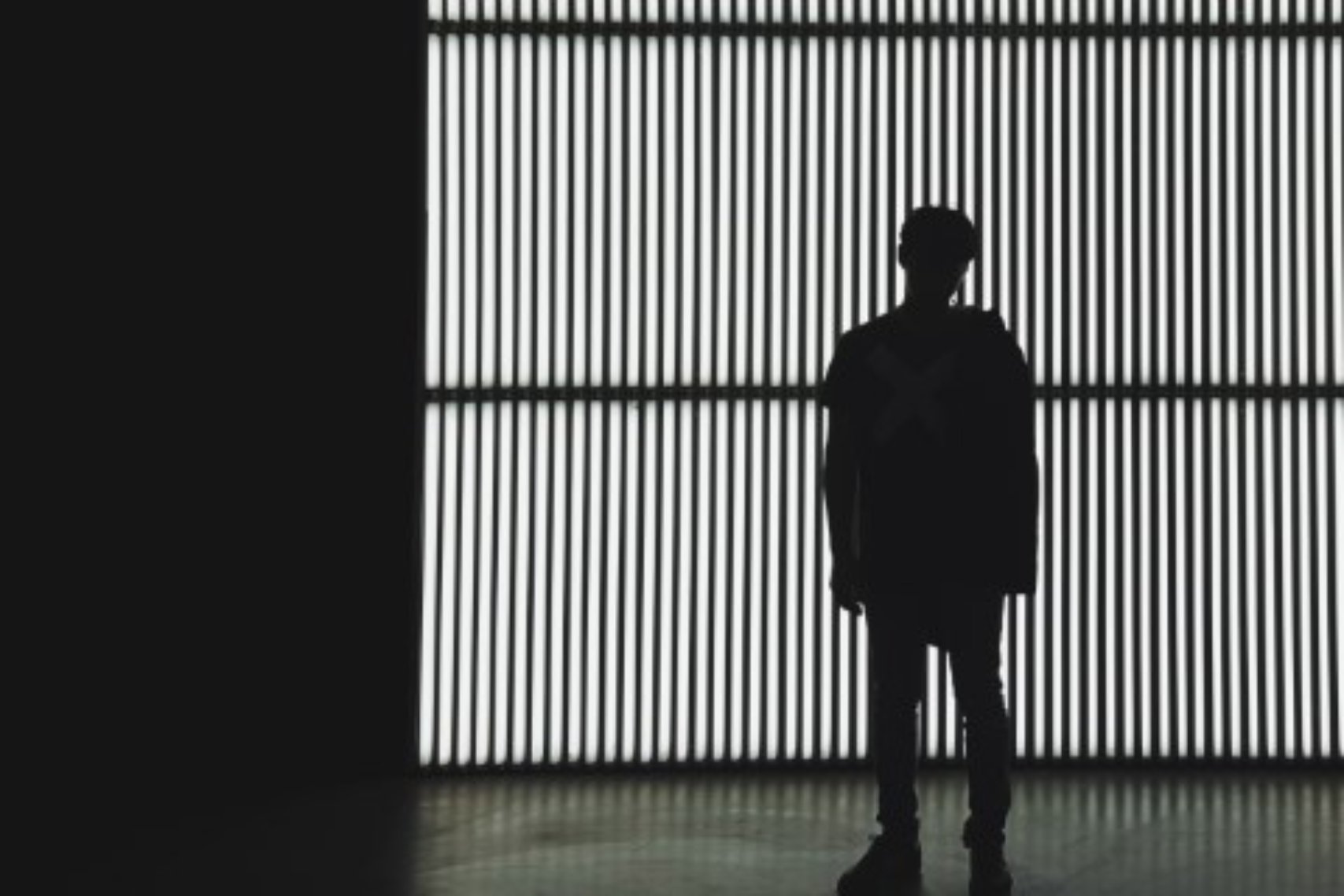 Silhouette of a person standing in a dark room