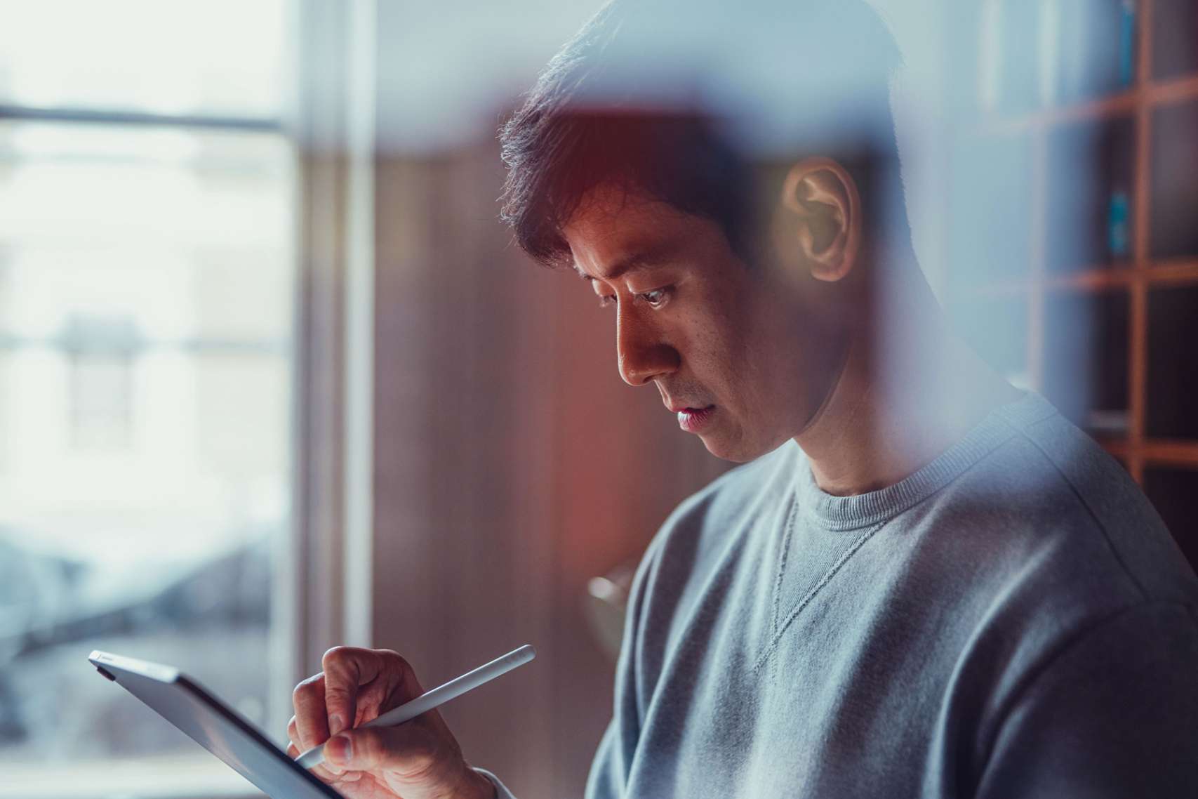 professional using a stylus to work on a digital tablet, representing modern design, digital art, or mobile workflows.