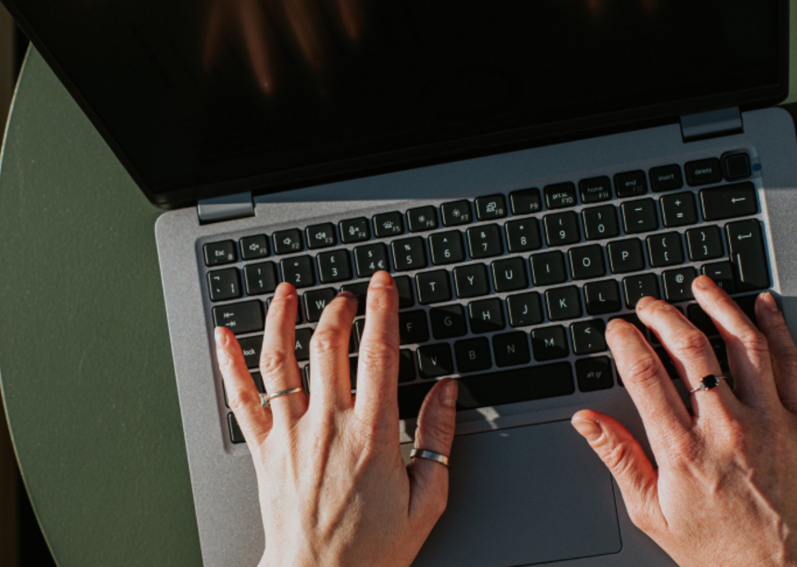 Hands typing on a laptop keyboard