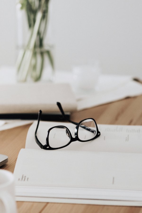 Notebook and glasses on table